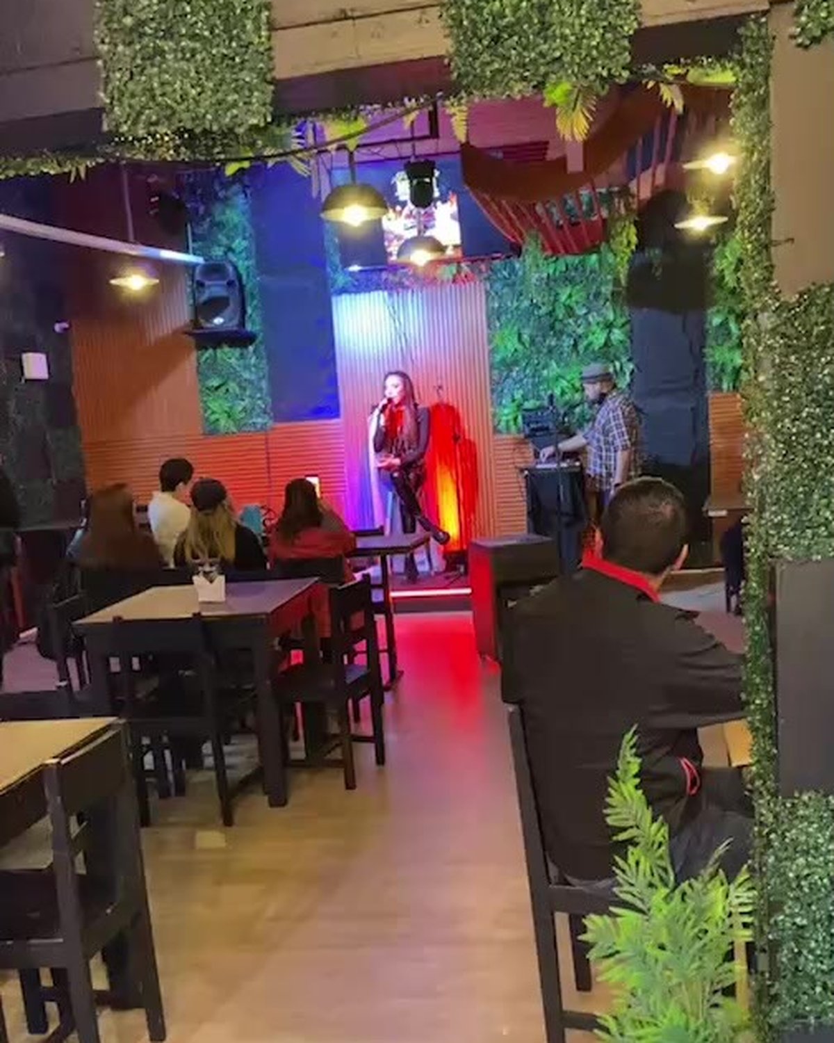 Interior con muro verde y show al fondo