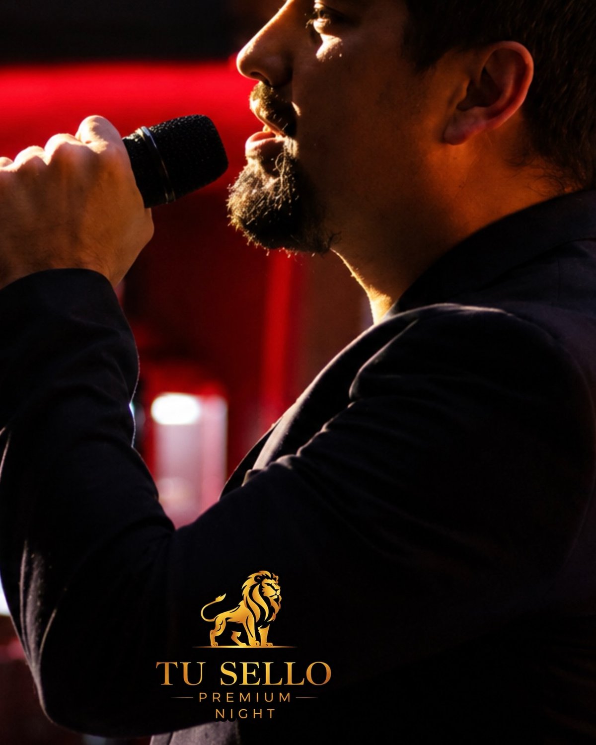 Hombre cantando karaoke con micrófono bajo luz roja en Tú Sello Night